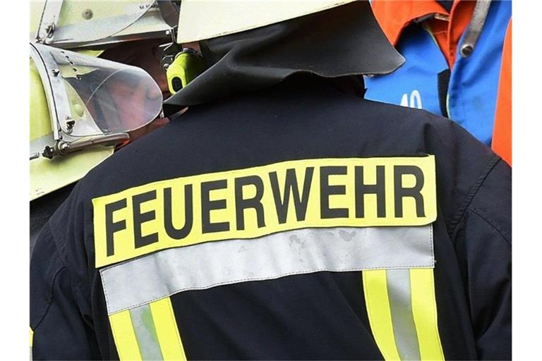 Der Schriftzug Feuerwehr steht an der Jacke eines Feuerwehrmannes. Foto: picture alliance / dpa/Symbolbild