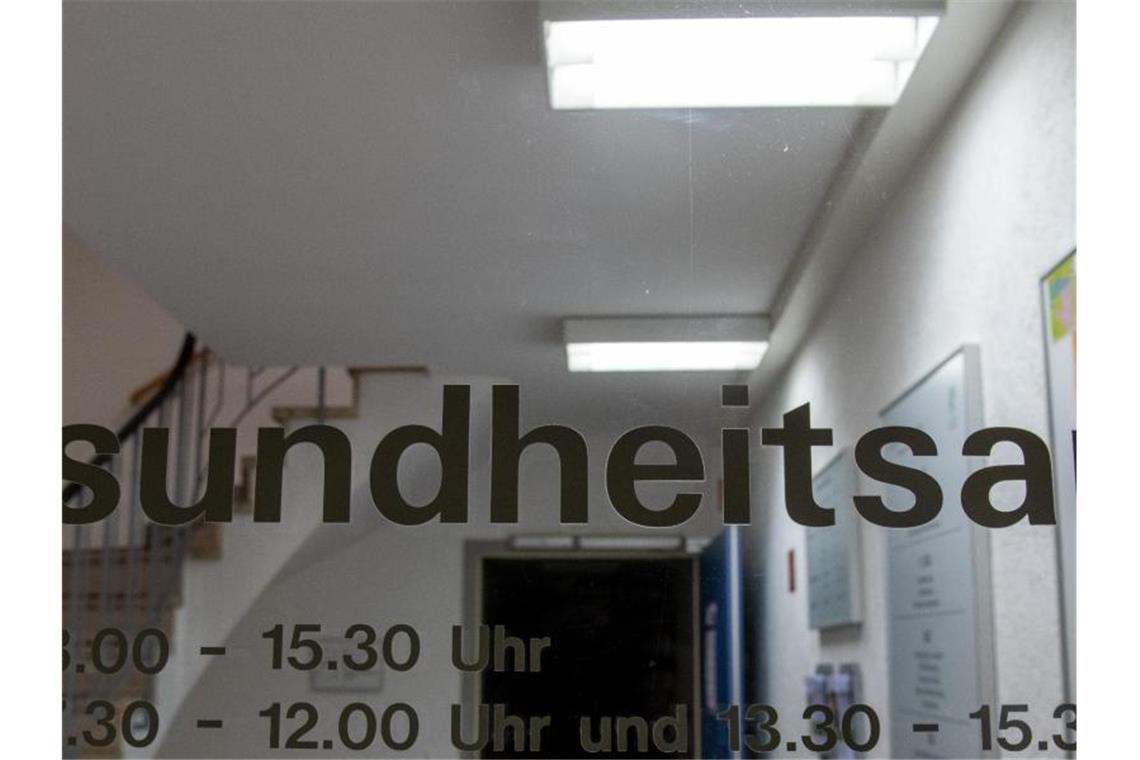 Der Schriftzug „Gesundheitsamt“ mit Öffnungszeiten ist an einer Tür zu lesen. Foto: Stefan Puchner/dpa/Archivbild