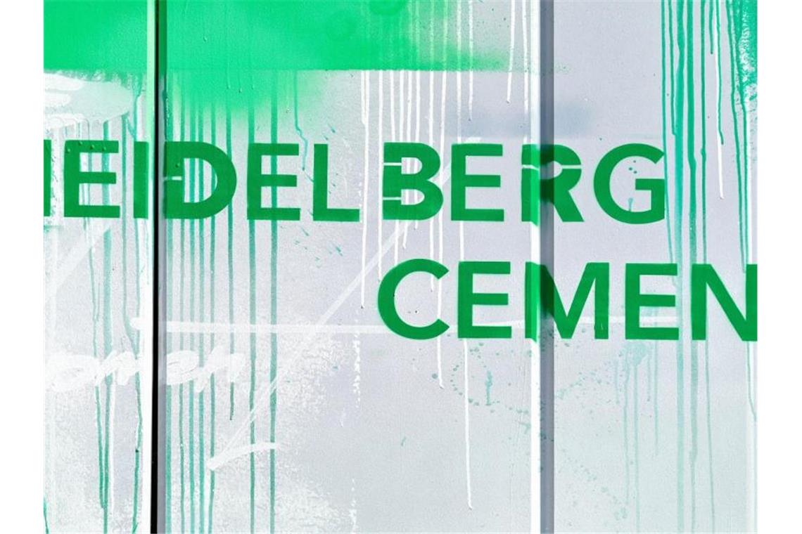Der Schriftzug „HeidelbergCement“ ist in grüner Farbe auf einer Mauer am HeidelbergCement Technology Center angebracht. Foto: Uwe Anspach/dpa/Symbolbild