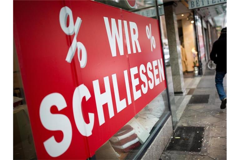 Der Schriftzug „Wir schliessen“ steht am Schaufenster eines Geschäftes auf einer Seitenstrasse der Düsseldorfer Königsallee. Foto: Martin Gerten/dpa
