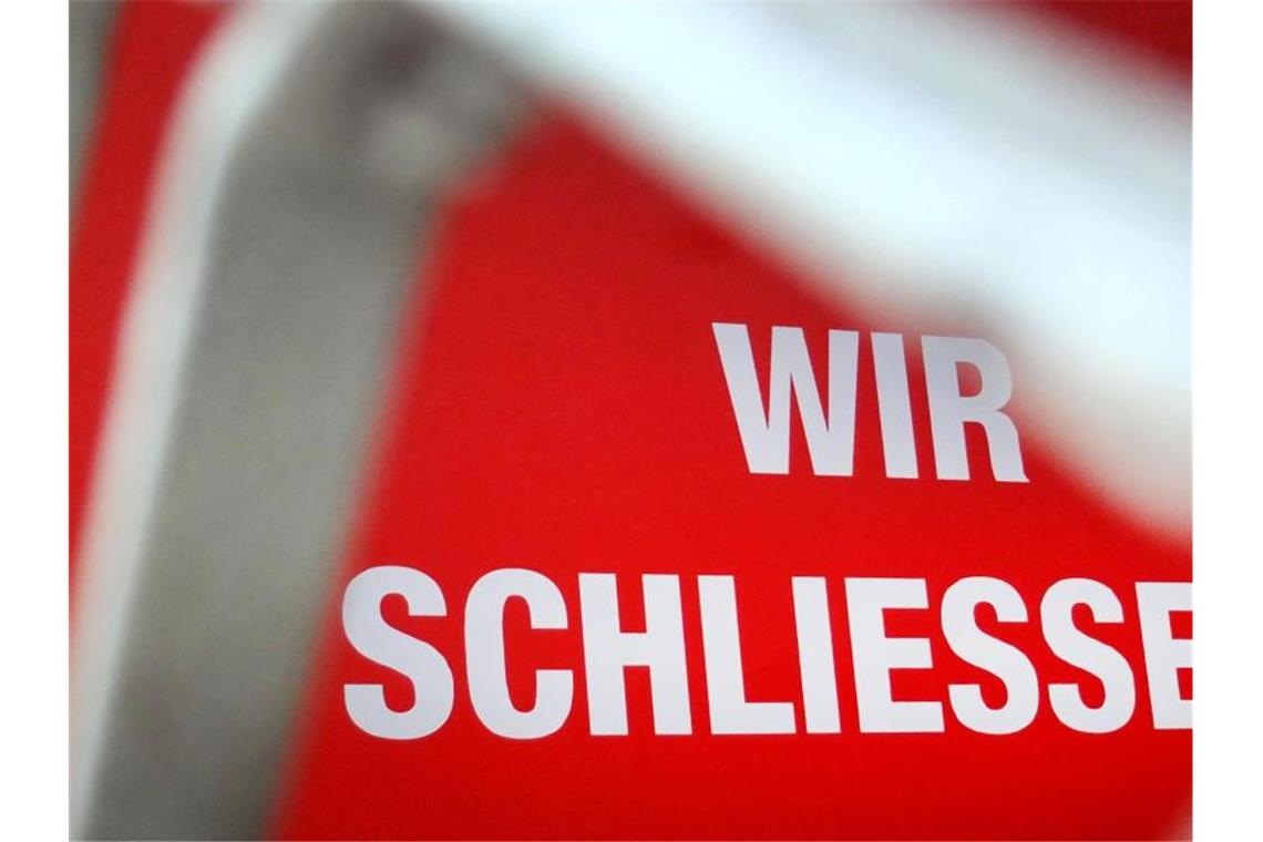 Klagewelle um Betriebsschließungsversicherungen Der Schriftzug „Wir schließen!“ steht hinter einem Rollgitter an einem geschlossenen Geschäft. Foto: Martin Gerten/dpa