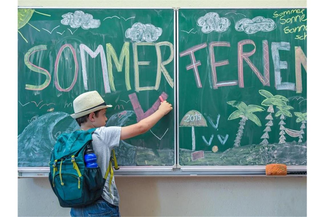 Zum Ferienstart wird es voll auf den Straßen im Südwesten Der Schüler malt in seinem Klassenraum an einer Tafel mit der Aufschrift „Sommerferien“. Foto: Patrick Pleul/Archiv