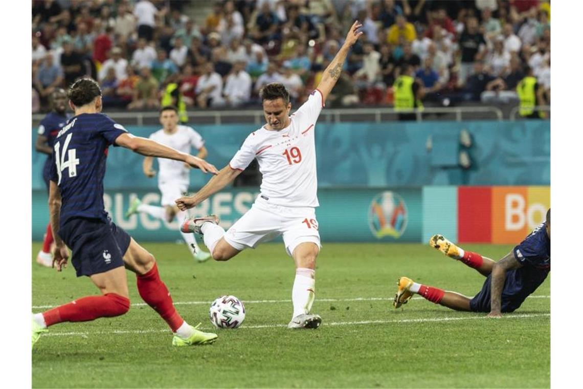 Der Schweizer Mario Gavranovic (M) erzielt das Tor zum 3:3 gegen die Abwehr der Franzosen Adrien Rabiot (l) und Presnel Kimpembe. Foto: Jean-Christophe Bott/KEYSTONE/dpa