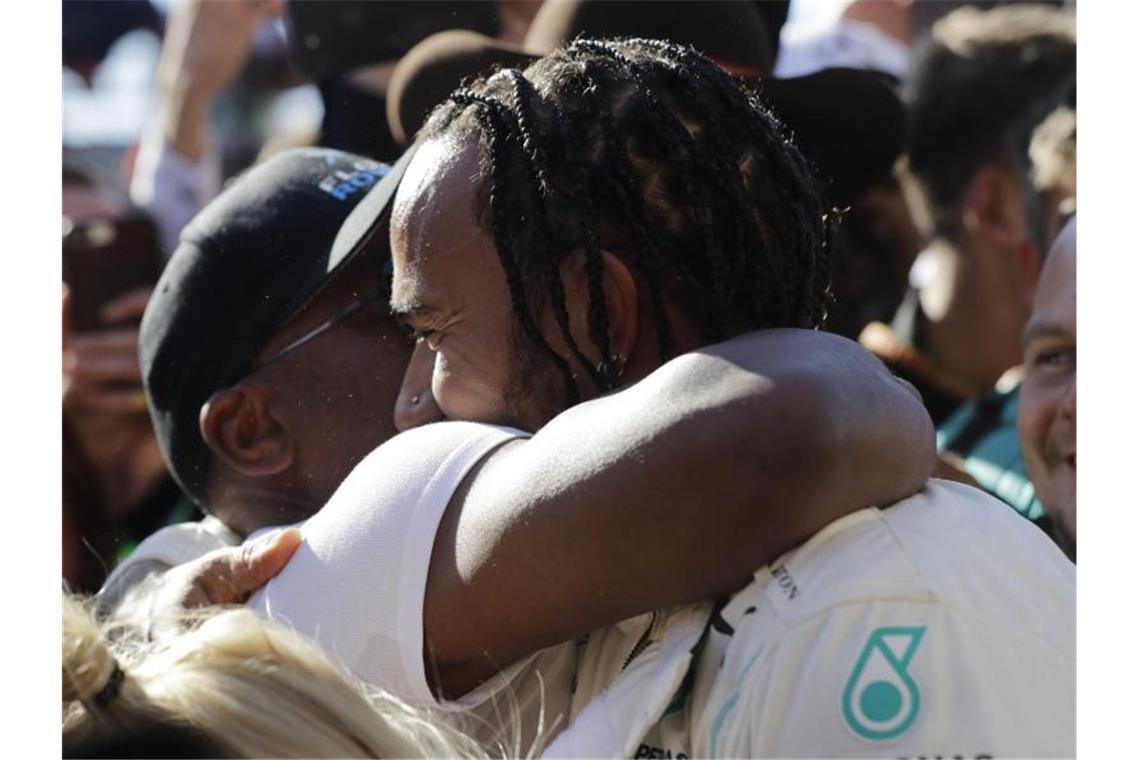 Der sechsmalige Weltmeister Lewis Hamilton (r) vom Team Mercedes umarmt seinen Vater. Foto: Darron Cummings/AP/dpa