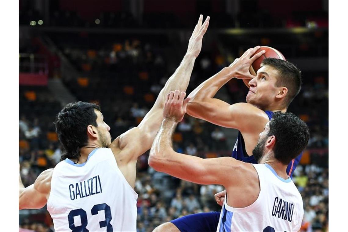 Der Serbe Bogdan Bogdanovic (M.) wird von den Argentiniern Tayavek Gallizzi (l) und Patricio Garino eng verteidigt. Foto: Xue Yubin/XinHua