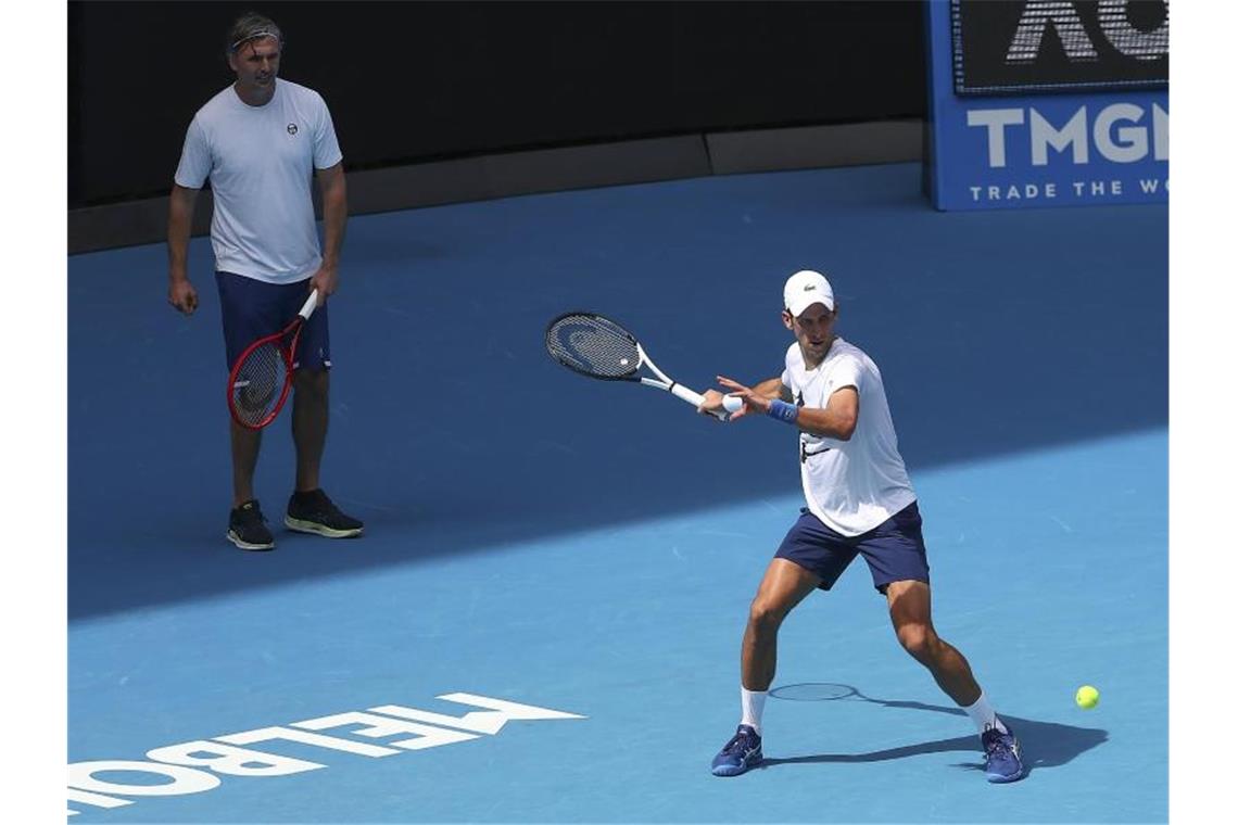 Ungereimtheiten bringen Djokovic in Bedrängnis Der serbische Titelverteidiger Novak Djokovic (r) wird von seinem Trainer während einer Trainingseinheit in der Rod Laver Arena beobachtet. Foto: Kelly Defina/Pool Getty Images/AP/dpa