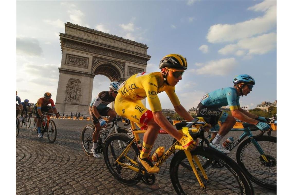 Der Slowene und Gesamtsieger Tadej Pogacar (M), der das gelbe Trikot des Gesamtführenden trägt, fährt am Arc de Triomphe vorbei. Foto: Christophe Ena/AP/dpa