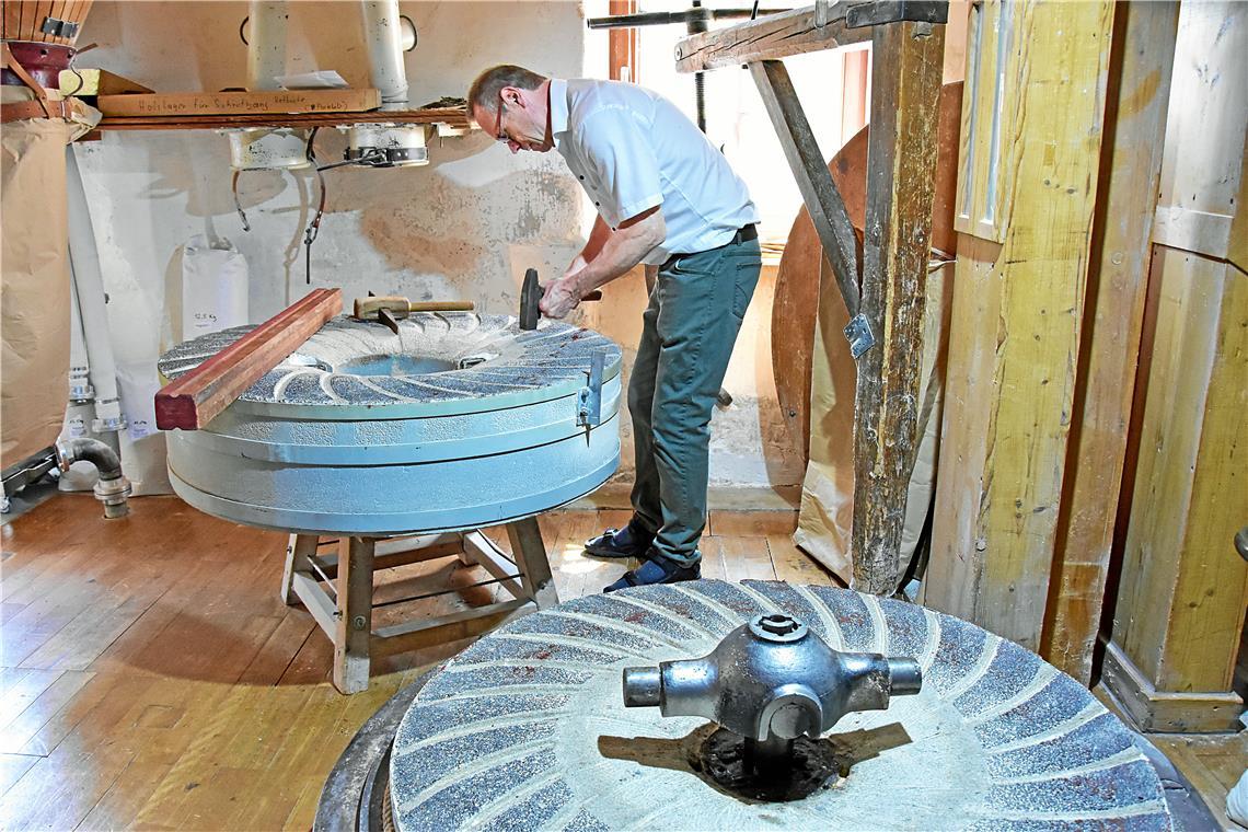 Feinstarbeit mit Zirkel und Krausshammer Der sogenannte Läufer, der obere der beiden Mühlsteine, wird von Manfred Thiel aufwendig bearbeitet. Foto: Tobias Sellmaier
