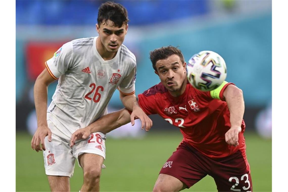 Der Spanier Pedri (l) im Zweikampf mit Xherdan Shaqiri. Foto: Kirill Kudryavtsev/Pool AFP/AP/dpa