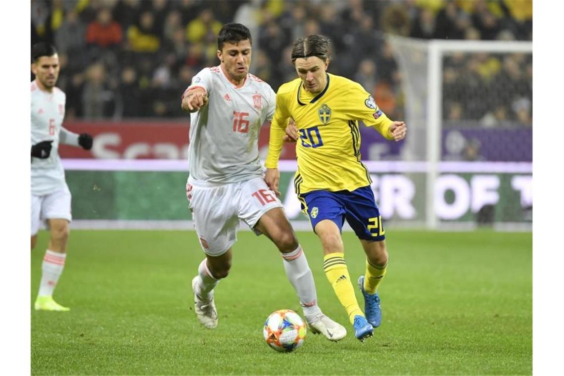Spaniens Last-Minute-Jubel: EM-Qualifikation geschafft Der Spanier Rodri (l) und Kristoffer Olsson aus Schweden im Kampf um den Ball. Foto: Jessica Gow/TT NEWS AGENCY/AP/dpa