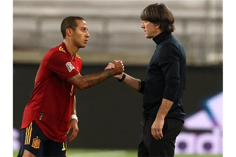 Der Spanier Thiago Alcantara und Bundestrainer Joachim Löw geben sich die Hand nach dem Spiel. Foto: Christian Charisius/dpa