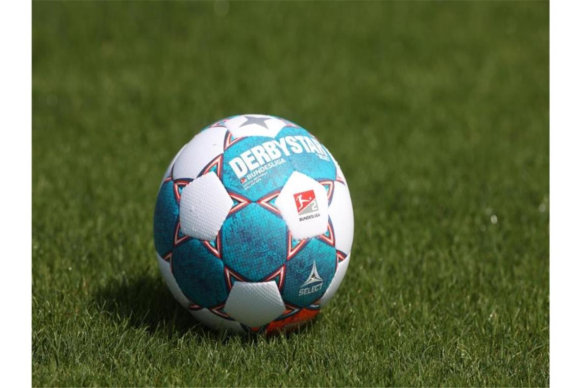 Der Spielball liegt auf dem Rasen. Foto: Guido Kirchner/dpa/Symbolbild