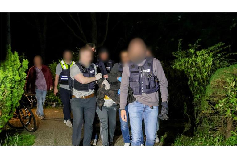 Der Tatverdächtige wird von Polizeibeamten abgeführt.