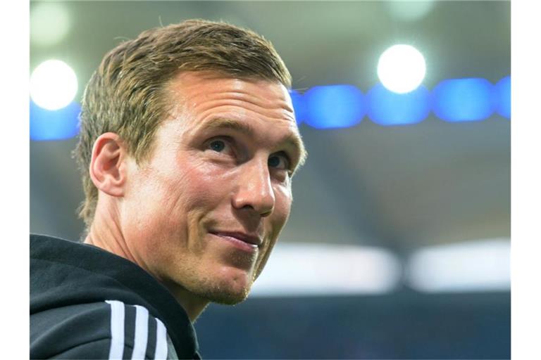 Der Trainer Hannes Wolf vom Hamburger SV lächelt nach oben schauend. Foto: Axel Heimken/dpa/Archivbild
