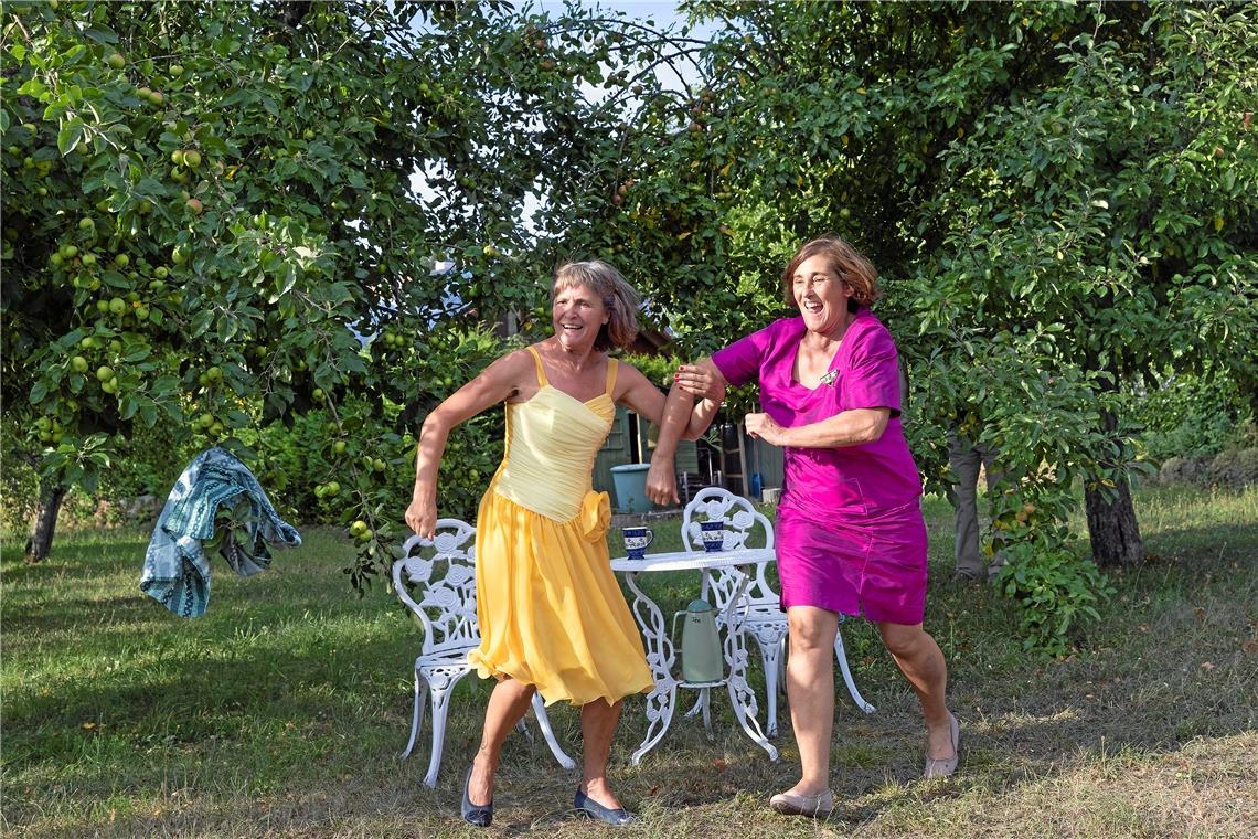 Ein Mosaik aus Theater, Kunst und Musik Der Überraschungsmoment kommt bei den Besuchern bestens an. Die beiden Frauen – Gerlinde Meyer (links) und Gabriele Gruber – die eben noch gemütlich unterm Apfelbaum Tee getrunken haben, reißen sich die Kittelschürzen vom Leib und stürmen in eleganten Kleidern davon. Foto: J. Fiedler