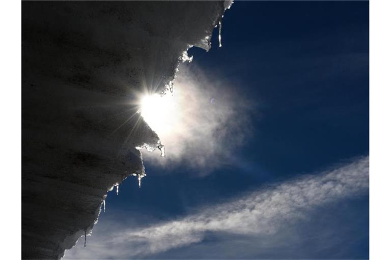 Der überstehende Schnee schmilzt an einem Stadeldach in der Sonne. Foto: Angelika Warmuth/dpa