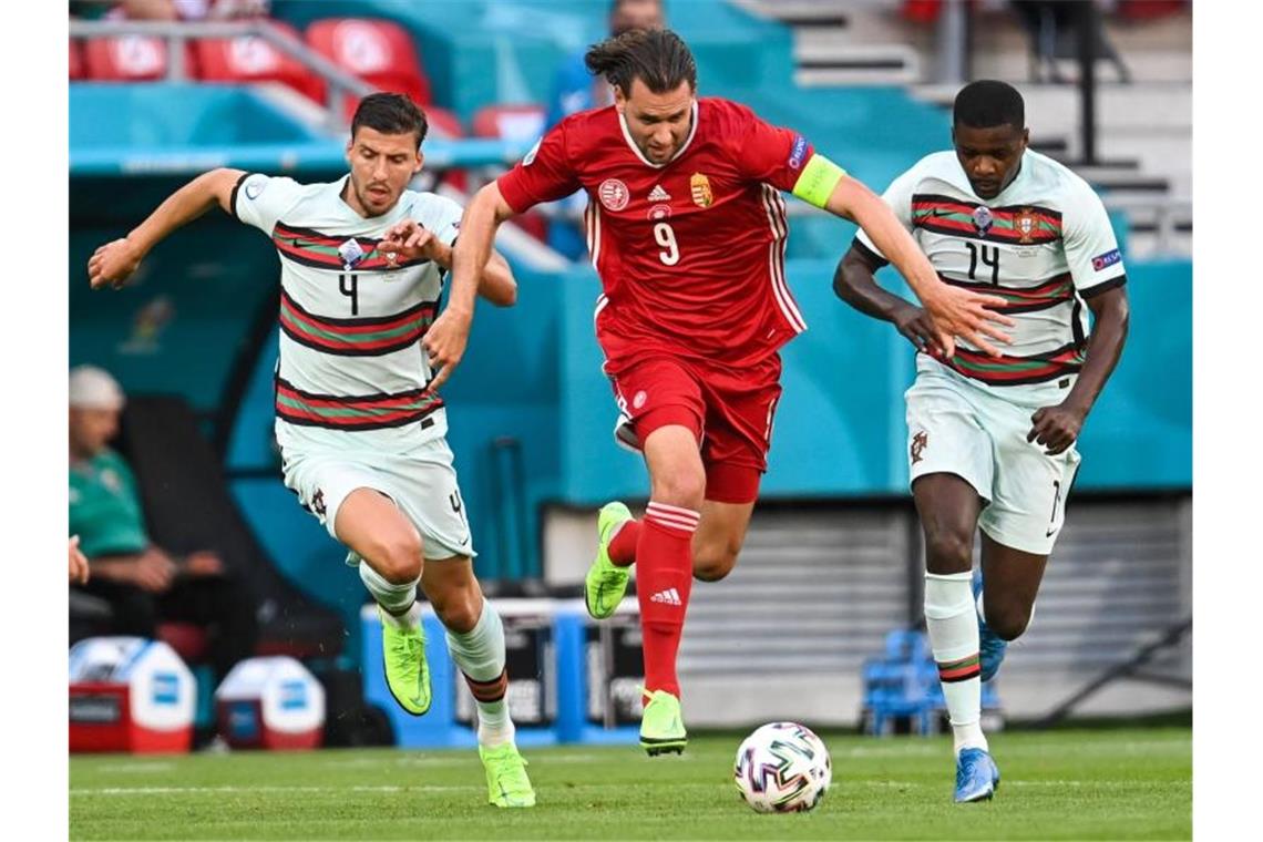 Der Ungarn Adam Szalai (M.) setzt sich gegen die Portugiesen Ruben Dias (l) und William Carvalho durch. Foto: Robert Michael/dpa-Zentralbild/dpa