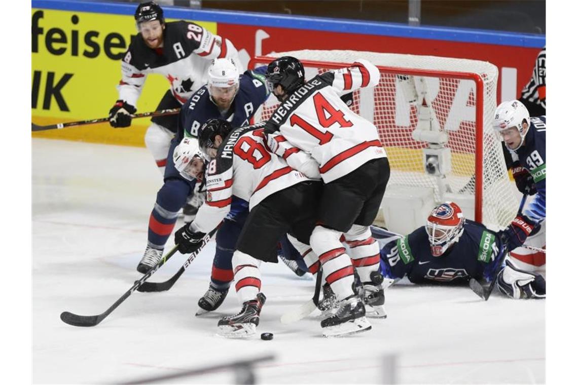 Der US-Amerikaner Colin Blackwell (2.v.l) verteidigt gegen Kanadas Andrew Mangiapane (4.v.l) und Adam Henrique (4.v.r). Foto: Sergei Grits/AP/dpa