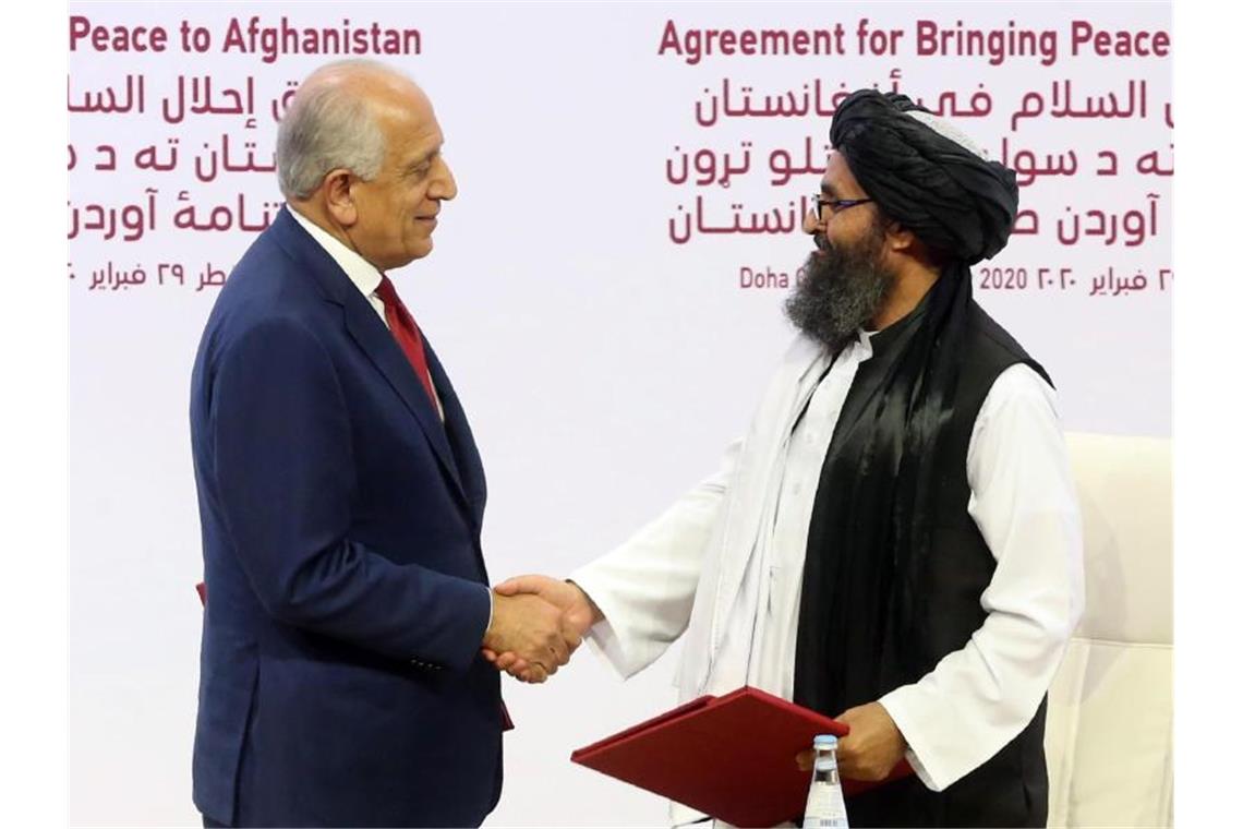 Der US-Sondergesandte Zalmay Khalilzad (l) und Mullah Abdul Ghani Baradar, Vertreter der Taliban, haben ein Abkommen über Wege zu einem Frieden zwischen den USA und der militant-islamistischen Taliban unterzeichnet. Foto: Hussein Sayed/AP/dpa