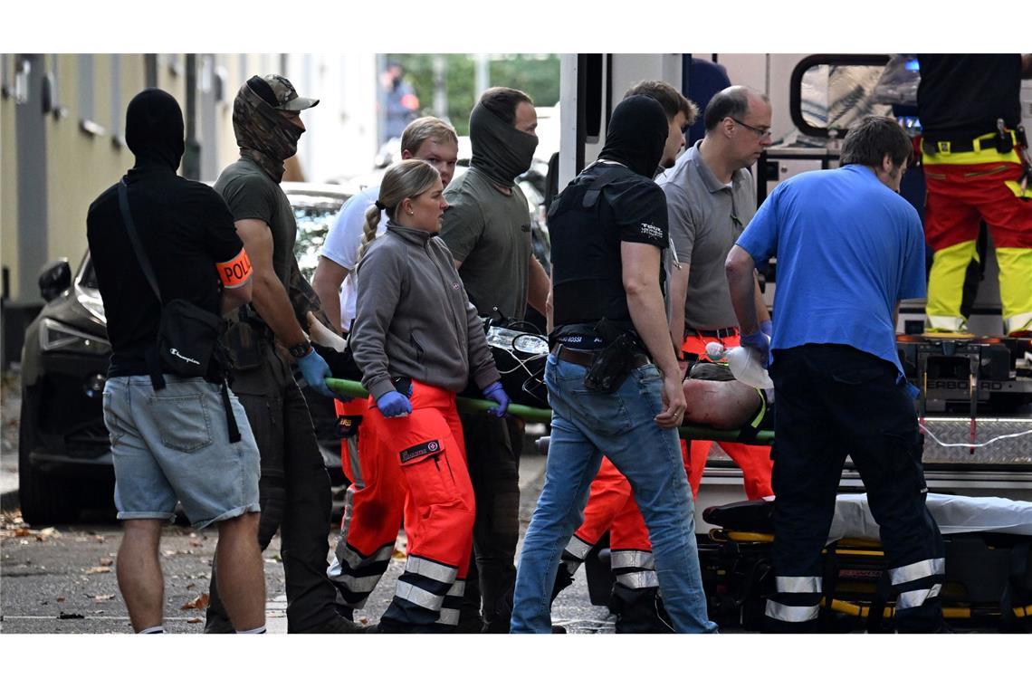 Der verletzte Tatverdächtige, der eine Lehrerin mit einem Messer angegriffen haben soll, wird zu einem Rettungswagen gebracht.