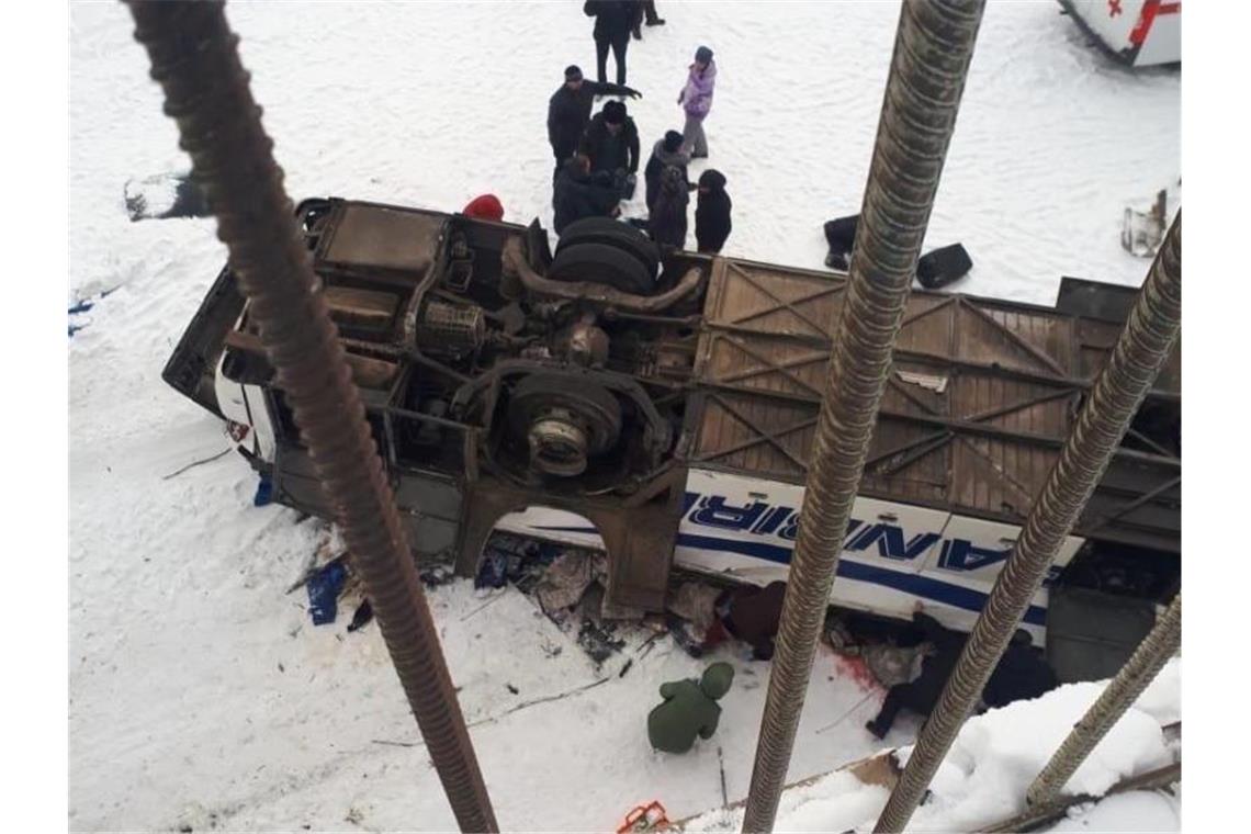 Der von einer Brücke gestürzte Bus liegt auf dem zugefrorenen Fluss. Foto: Sputnik/XinHua/dpa