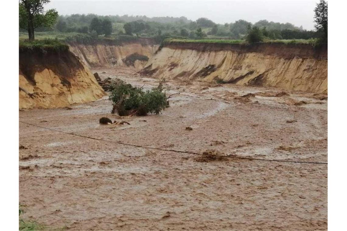 Flutkatastrophe trifft auch viele Unternehmen hart Der vor einigen Jahren wegen des Tagebaus umgelegte Fluss Inde hat sich nach schweren Regenfällen ein neues Bett gegraben und strömt unkontrolliert in den Braunkohle-Tagebau Inden. ). Foto: Olaf Rossbroich/dpa