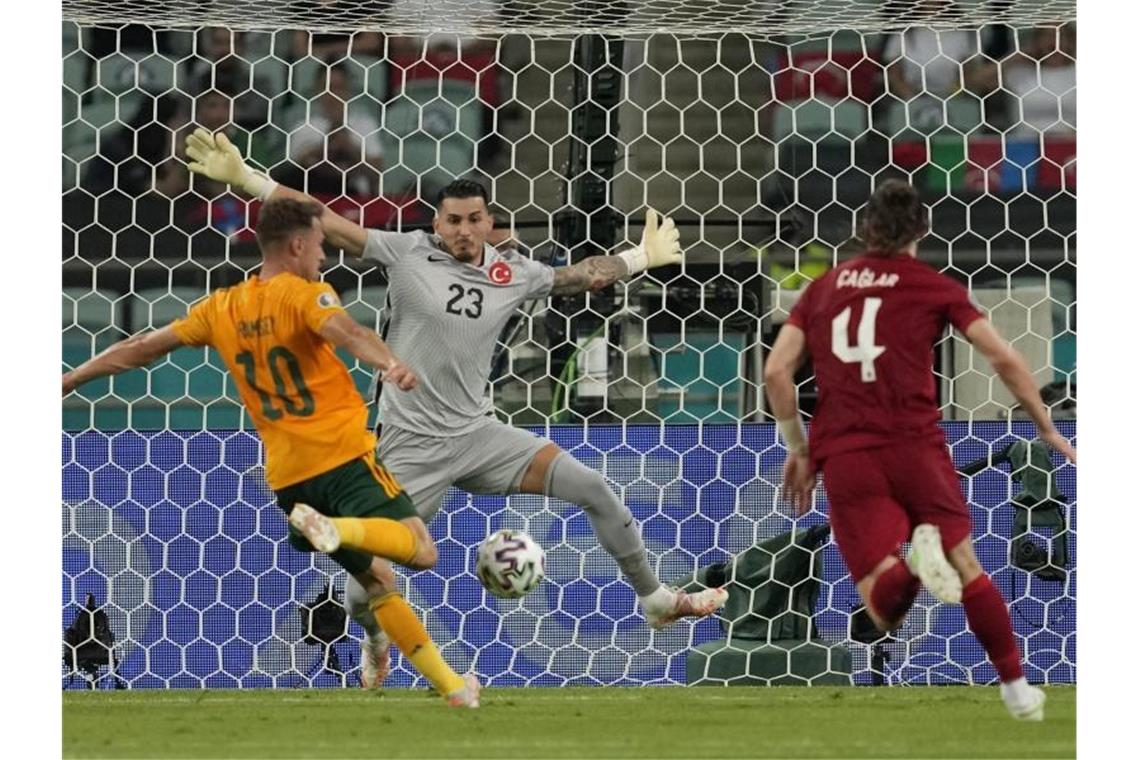 Der Waliser Aaron Ramsey (l/10) überwindet bei seinem Schuss den türkischen Torhüter Ugurcan Cakir (M). Foto: Darko Vojinovic/AP Pool/dpa