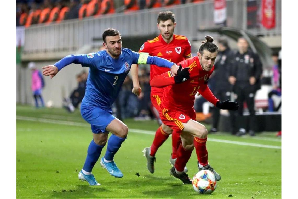 Wales darf auf EM-Teilnahme hoffen - Comeback von Bale Der Waliser Gareth Bale (r) setzt sich mit dem Ball gegen Gara Garayev aus Aserbaidschan durch. Foto: Bradley Collyer/PA Wire/dpa