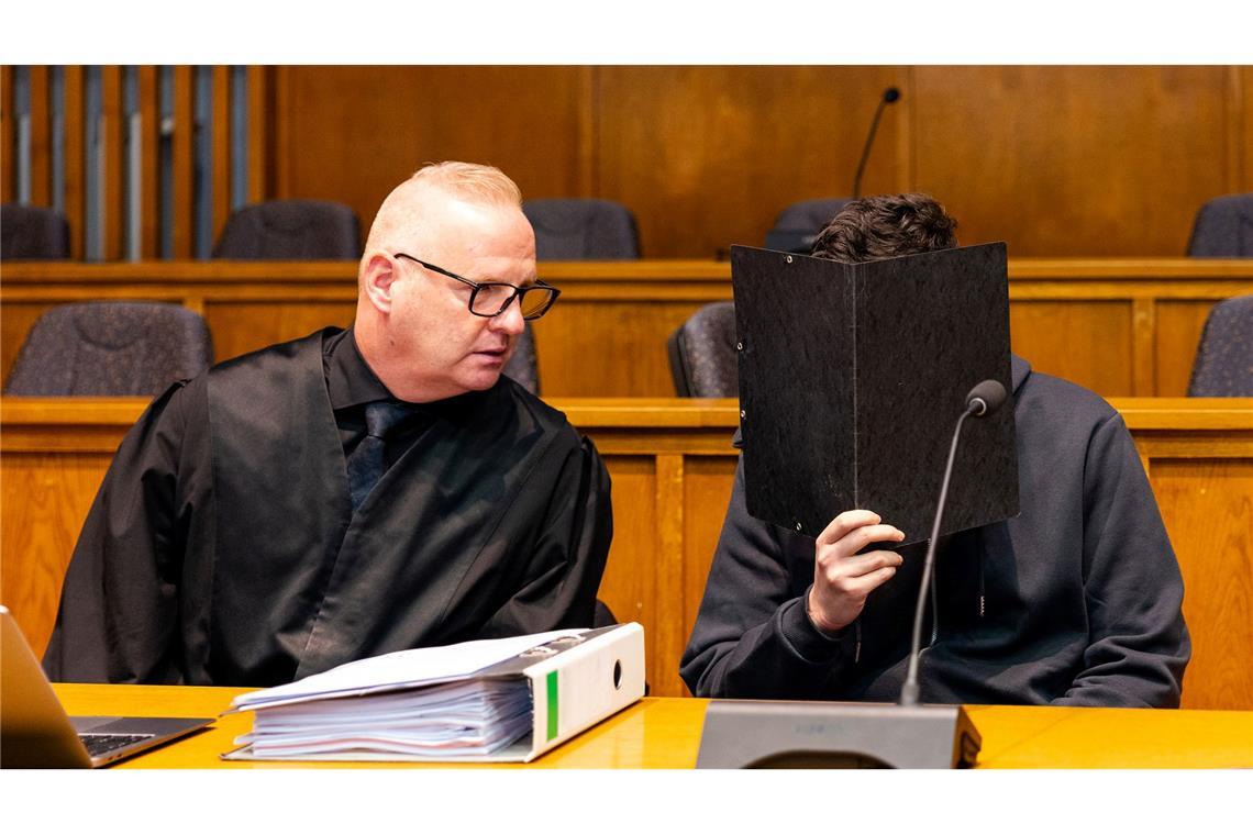 Der wegen Mordes angeklagte junge Mann sitzt neben seinem Verteidiger Michael Rehberger im Landgericht Saarbrücken.