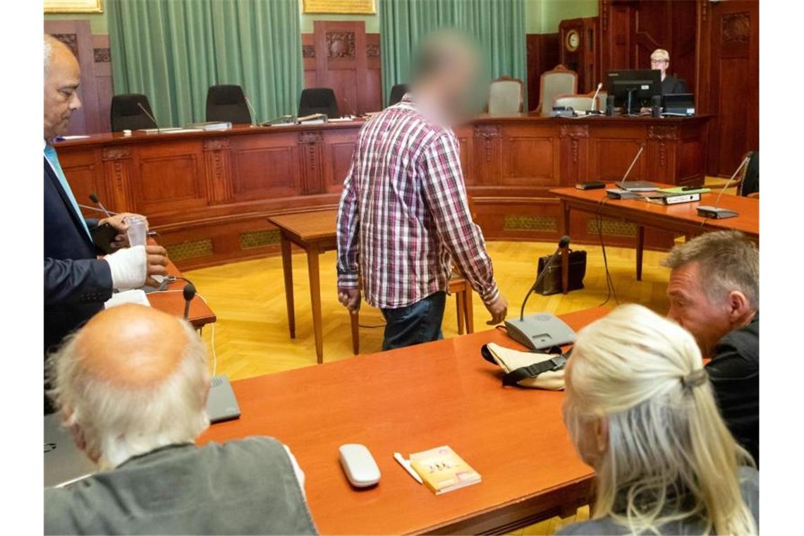 Fernfahrer gesteht Tötung der Tramperin Sophia Der wegen Mordes angeklagte Marokkaner (M.) betritt den Gerichtssaal. Im Vordergrund sitzen Andreas Lösche (r.), Bruder der ermordeten Tramperin Sophia Lösche, mit seinen Eltern. Foto: Daniel Karmann