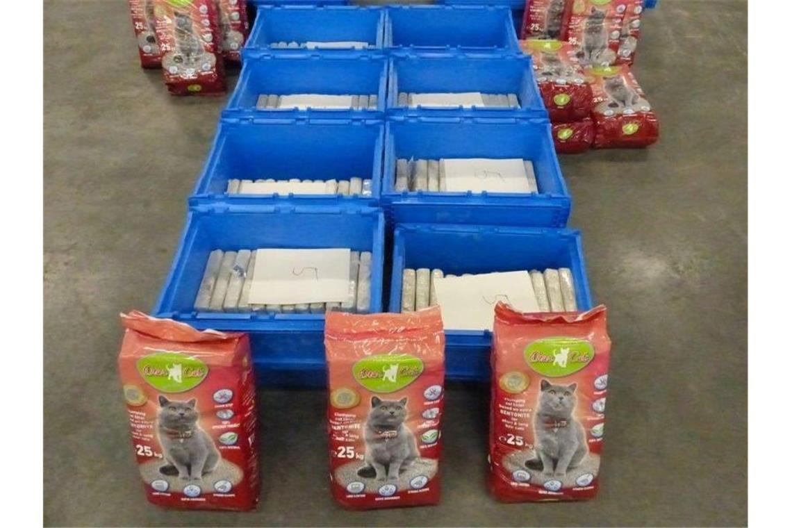 Der Zoll präsentiert das gefundene Kokain und Säcke mit Katzenstreu. Foto: -/Zoll Hamburg/dpa