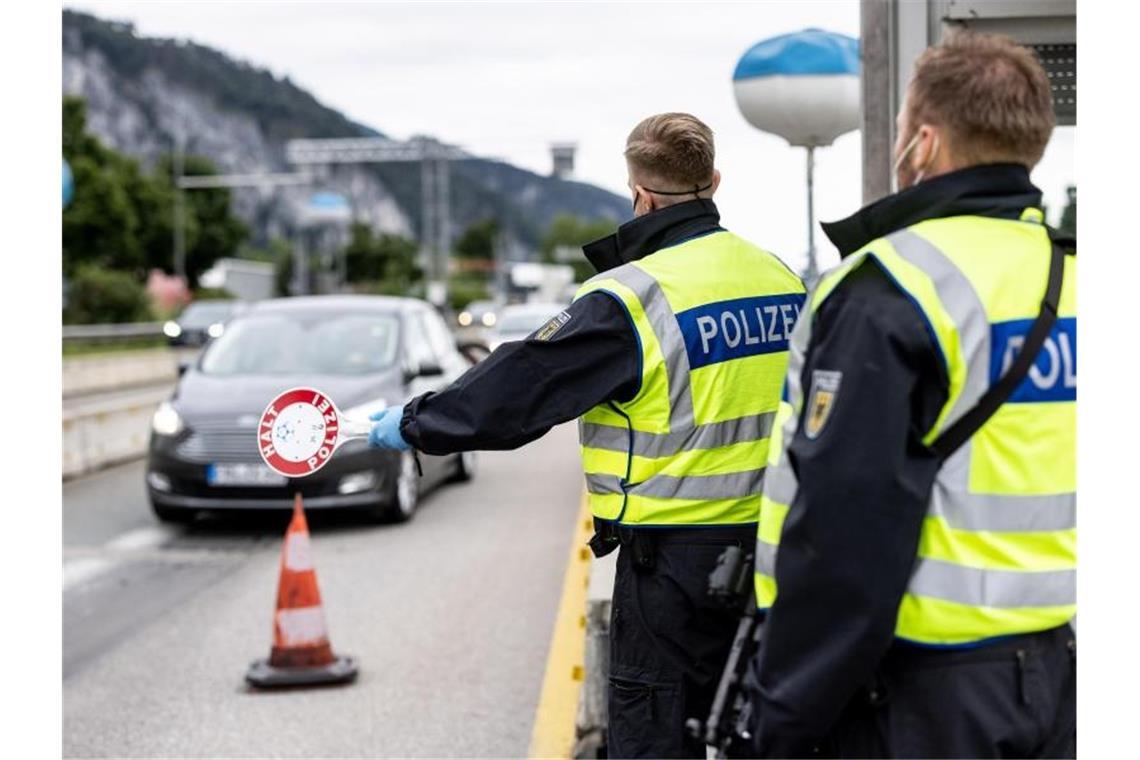 Deutsche Bundespolizisten beobachten an der Grenze zu Österreich auf der Autobahn A93 den Verkehr. Foto: Matthias Balk/dpa