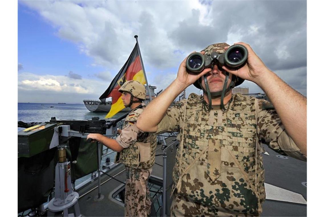 Deutsche Marine-Soldaten halten an Bord der Fregatte „Karlsruhe“ an einem Maschinengewehr Wache. Foto: Gero Breloer