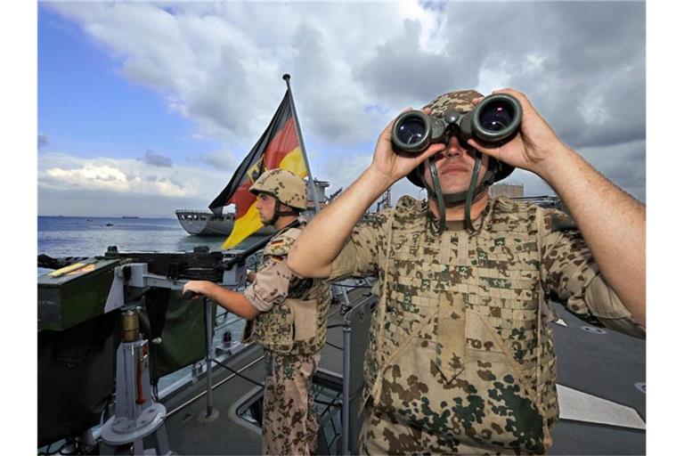 Deutsche Marine-Soldaten halten an Bord der Fregatte „Karlsruhe“ an einem Maschinengewehr Wache. Foto: Gero Breloer