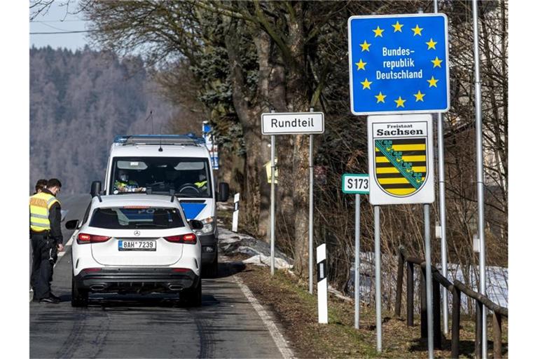 Deutsche Polizeibeamte kontrollieren ein Fahrzeug am tschechisch-deutschen Grenzübergang Petrovice/Bahratal im Erzgebirge. Foto: Ondøej Hájek/CTK/dpa
