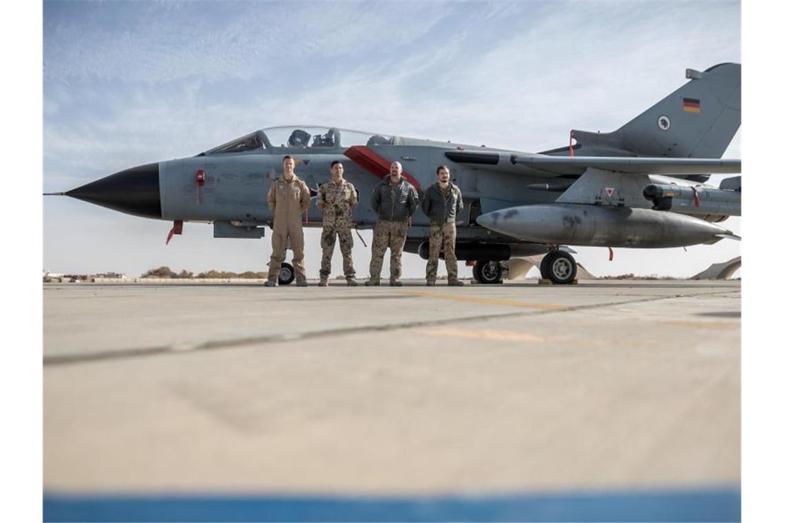 Deutsche Soldaten stehen neben einem Tornado-Jet der Bundeswehr auf der Al-Asrak-Airbase. Foto: Michael Kappeler/dpa