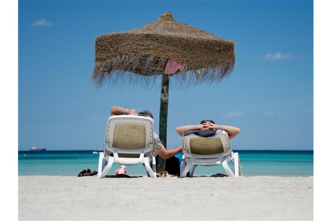 Deutsche Urlauber liegen an einem Strand im Norden der Mittelmeerinsel Mallorca. Doch nicht alle kommen auf diesen Genuss. Foto. Julian Stratenschulte Foto: Julian Stratenschulte