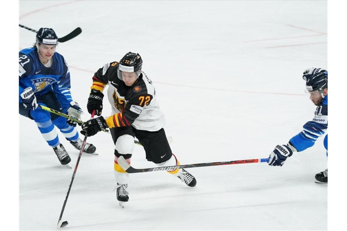 „Bronze - egal wie“: DEB-Team verpasst Endspiel unglücklich Deutschlands Dominik Kahun (M) kämpft mit Finnlands Jere Innala (l) und Iiro Pakarinen um den Puck. Foto: Roman Koksarov/dpa