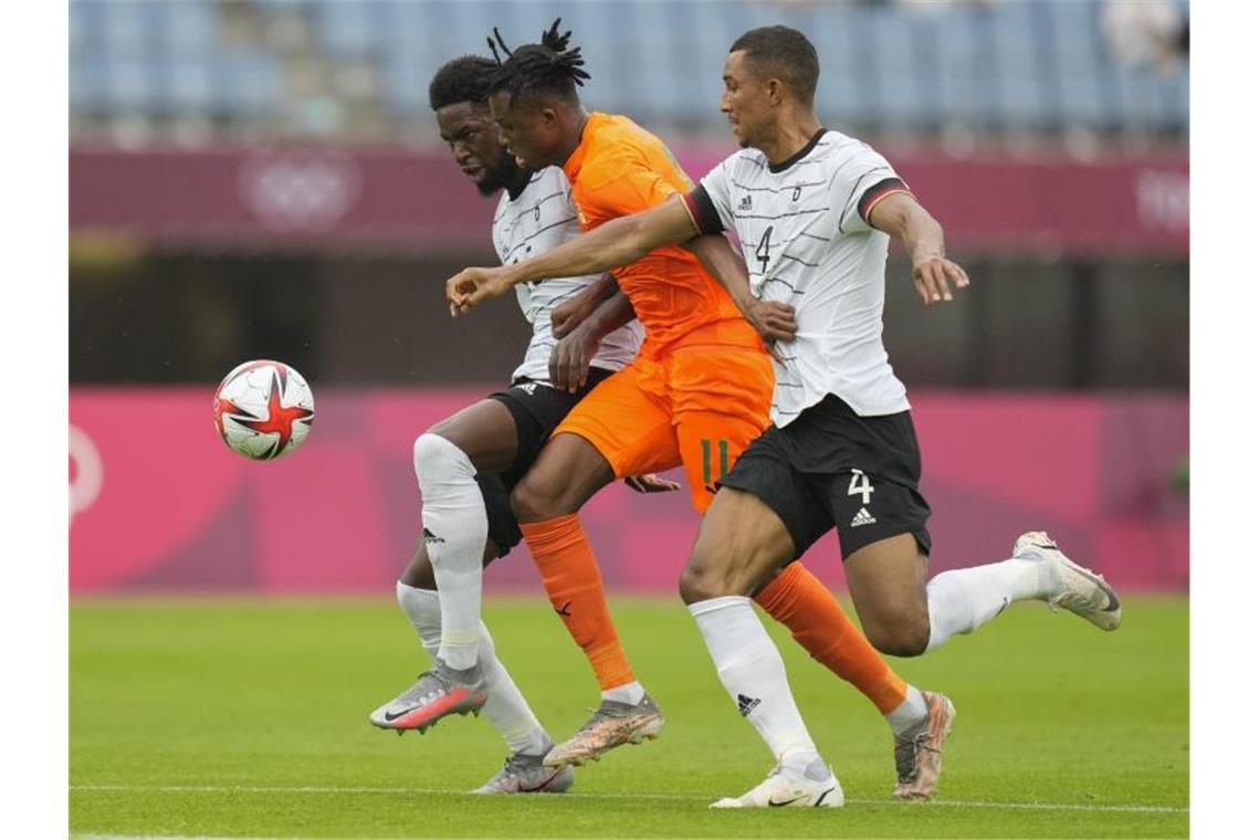 Deutschlands Felix Uduokhai (r) und Jordan Torunarigha (l) nehmen Christian Kouame in die Zange. Foto: Andre Penner/AP/dpa