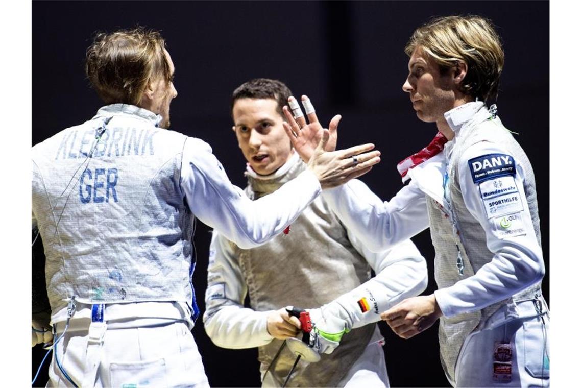 Deutsche Medaillen-Hoffnung ruht auf den Florettfechtern Deutschlands Florettfechter Benjamin Kleibrink (l-r), Andre Sanita und Peter Joppich klatschen sich ab. Foto: Marius Becker