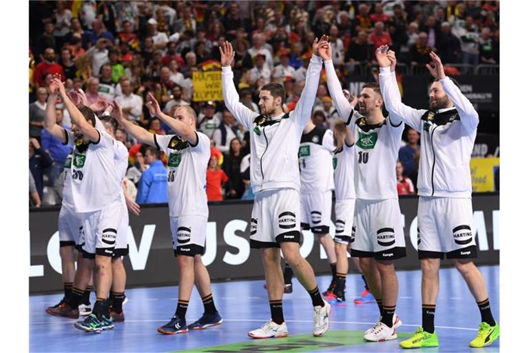 Deutschlands Handballer feiern mit dem Publikum den Sieg über Spanien. Foto: Marius Becker