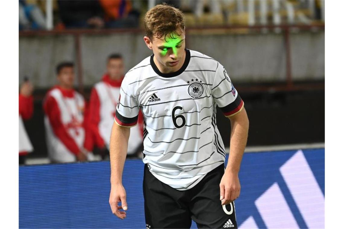 Fünfter Flick-Sieg bringt WM-Ticket: Werner-Tore beim 4:0 Deutschlands Joshua Kimmich wird während der Partie von einem Laserpointer geblendet. Foto: Federico Gambarini/dpa