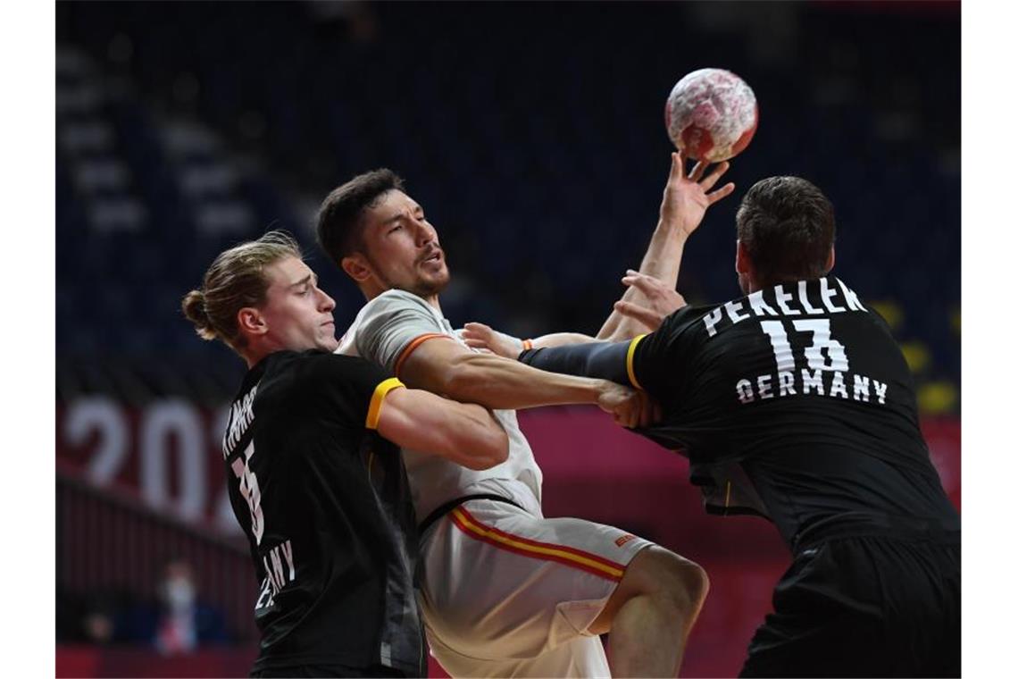 Frust und Enttäuschung: Handballer verlieren Auftakt Deutschlands Juri Knorr (l) und Hendrik Pekeler in Aktion mit Spaniens Alex Dujshebaev Dobichebaeva. Foto: Swen Pförtner/dpa