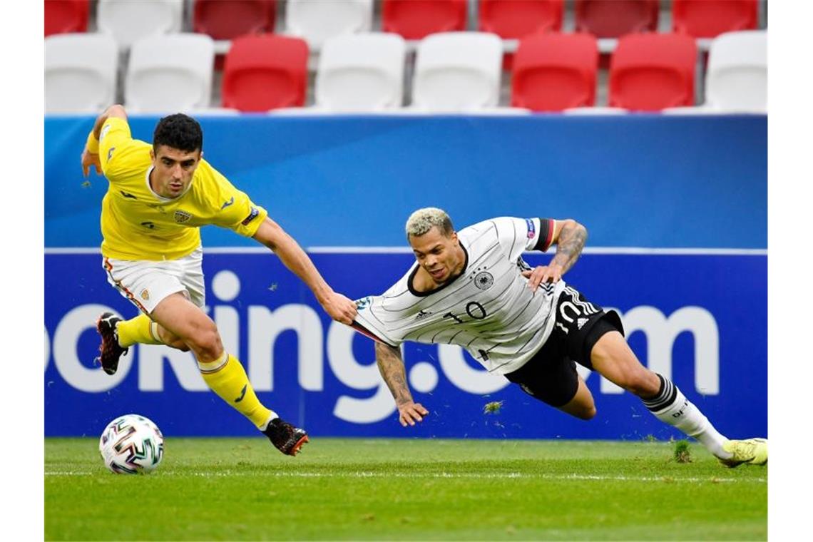 U21 zittert sich ins Viertelfinale - „Grund zum Feiern“ Deutschlands Lukas Nmecha in Aktion gegen den Rumänen Alexandru Pascanu (l). Foto: Marton Monus/dpa