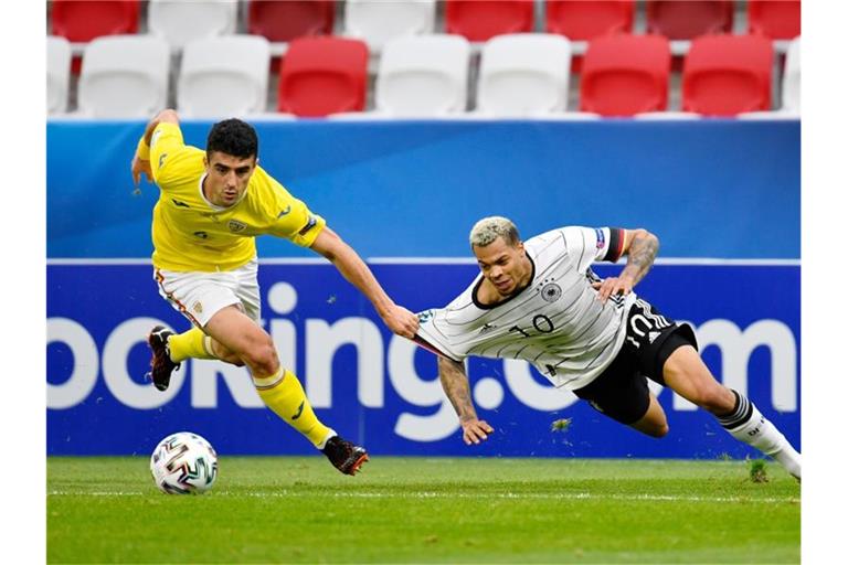 Deutschlands Lukas Nmecha in Aktion gegen Rumäniens Alexandru Pascanu (l). Foto: Marton Monus/dpa