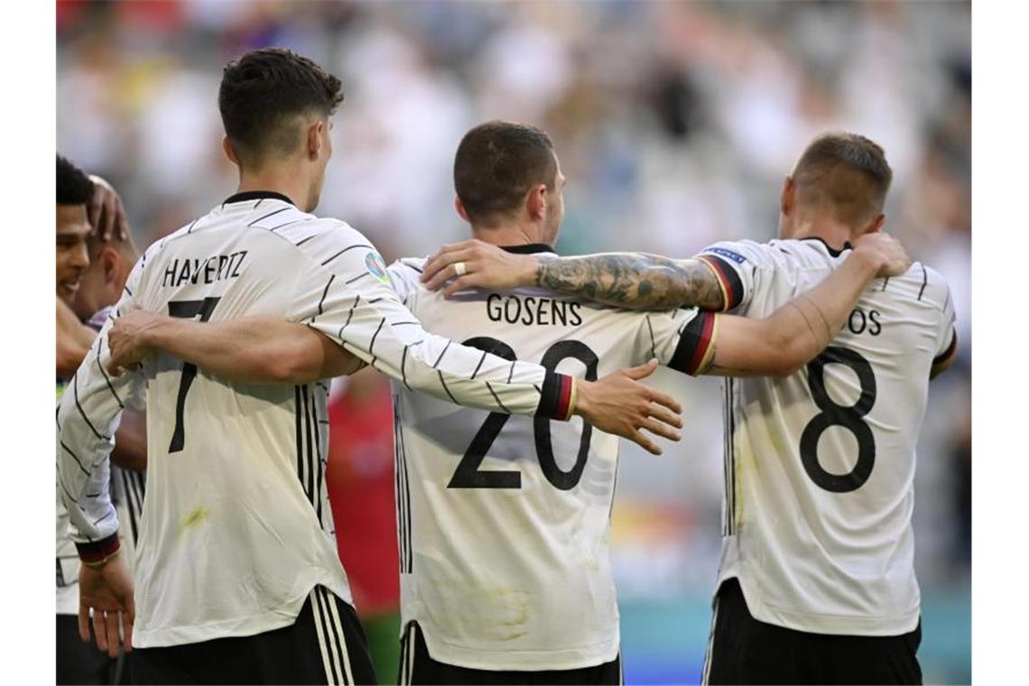 Deutschlands „Man of the Match“ Robin Gosens (M) feiert mit Kai Havertz und Toni Kroos (r). Foto: Philipp Guelland/EPA Pool/dpa