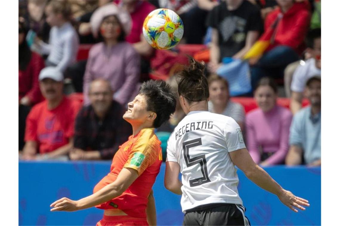 Zitterstart mit Happy End: DFB-Elf beklagt Chinas Härte Deutschlands Marina Hegering (r) im Kopfballduell mit der Chinesin Shanshan Wang. Foto: Sebastian Gollnow