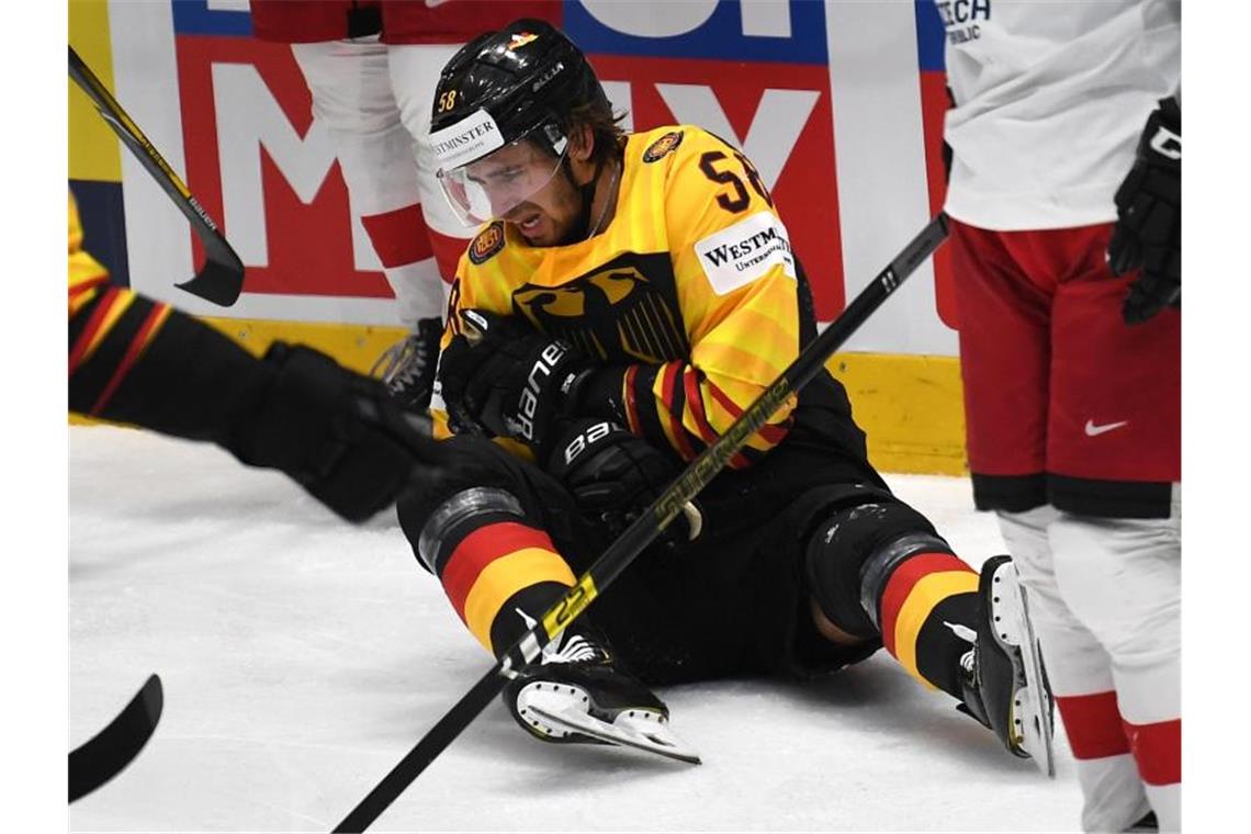 Deutschlands Markus Eisenschmid, Spieler bei Adler Mannheimm, sitzt verletzt auf dem Eis. Foto: Monika Skolimowska/zb/dpa/Archivbild