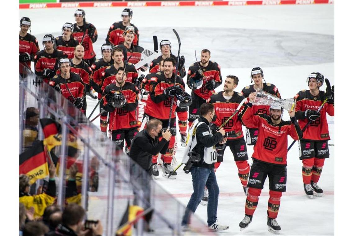 DEB-Team weckt mit Deutschland-Cup-Sieg Olympia-Vorfreude Deutschlands Spieler drehen nach dem Sieg eine Ehrenrunde mit dem Pokal. Foto: Bernd Thissen/dpa