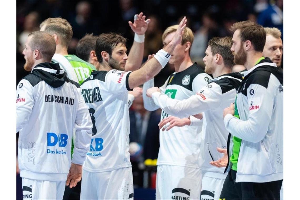 Deutsche Handballer nach Zittersieg in der Hauptrunde Deutschlands Spieler um Uwe Gensheimer (M/l) klatschen nach dem Sieg über Lettland ab. Foto: Robert Michael/dpa-Zentralbild/dpa